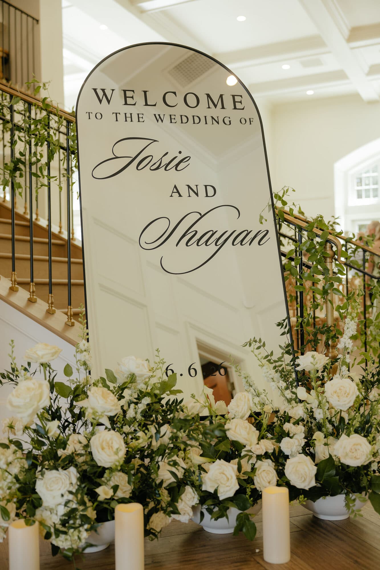 Welcome sign for a wedding ceremony surrounded by white florals
