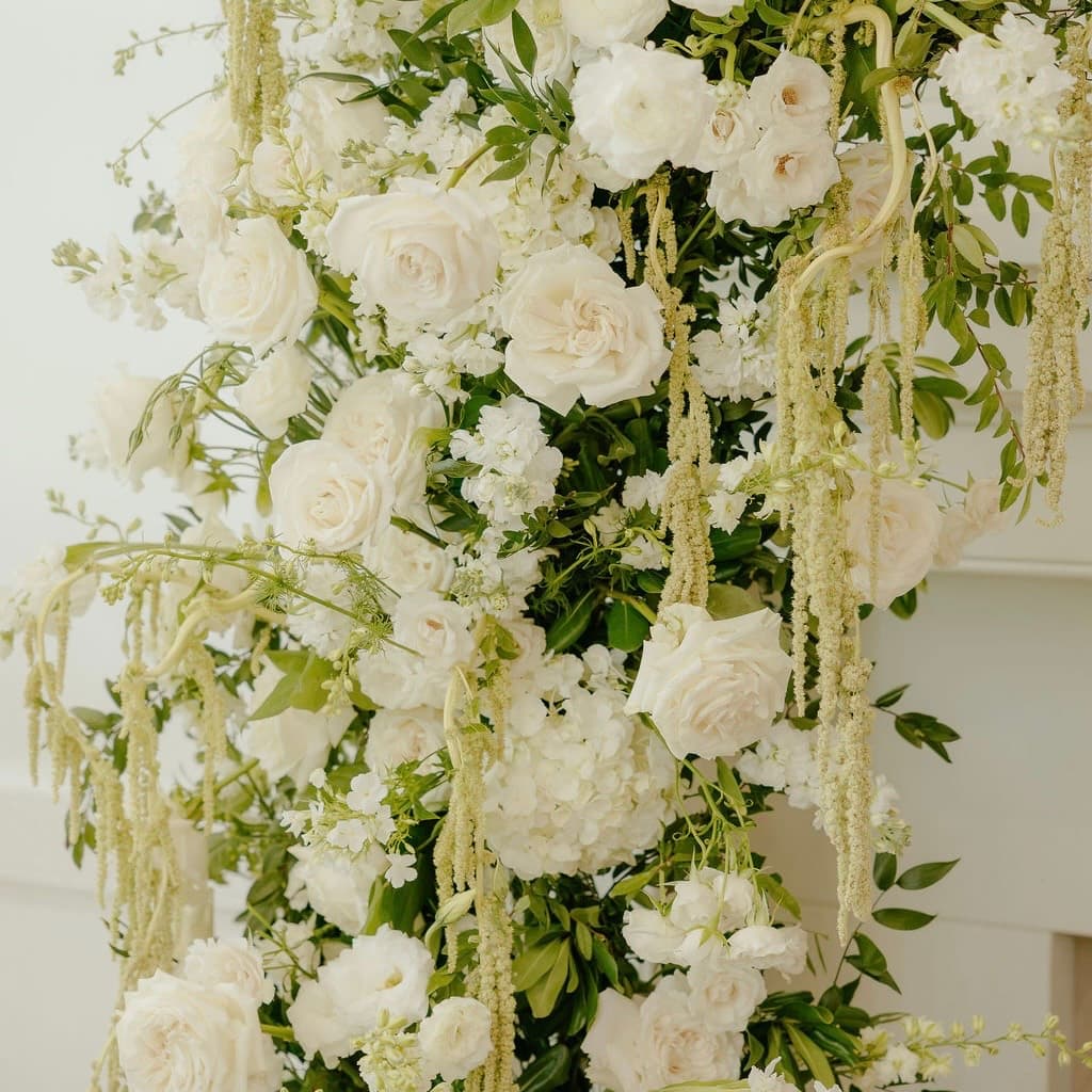 Close view of a white rose installation with cascading amaranthus and greenery